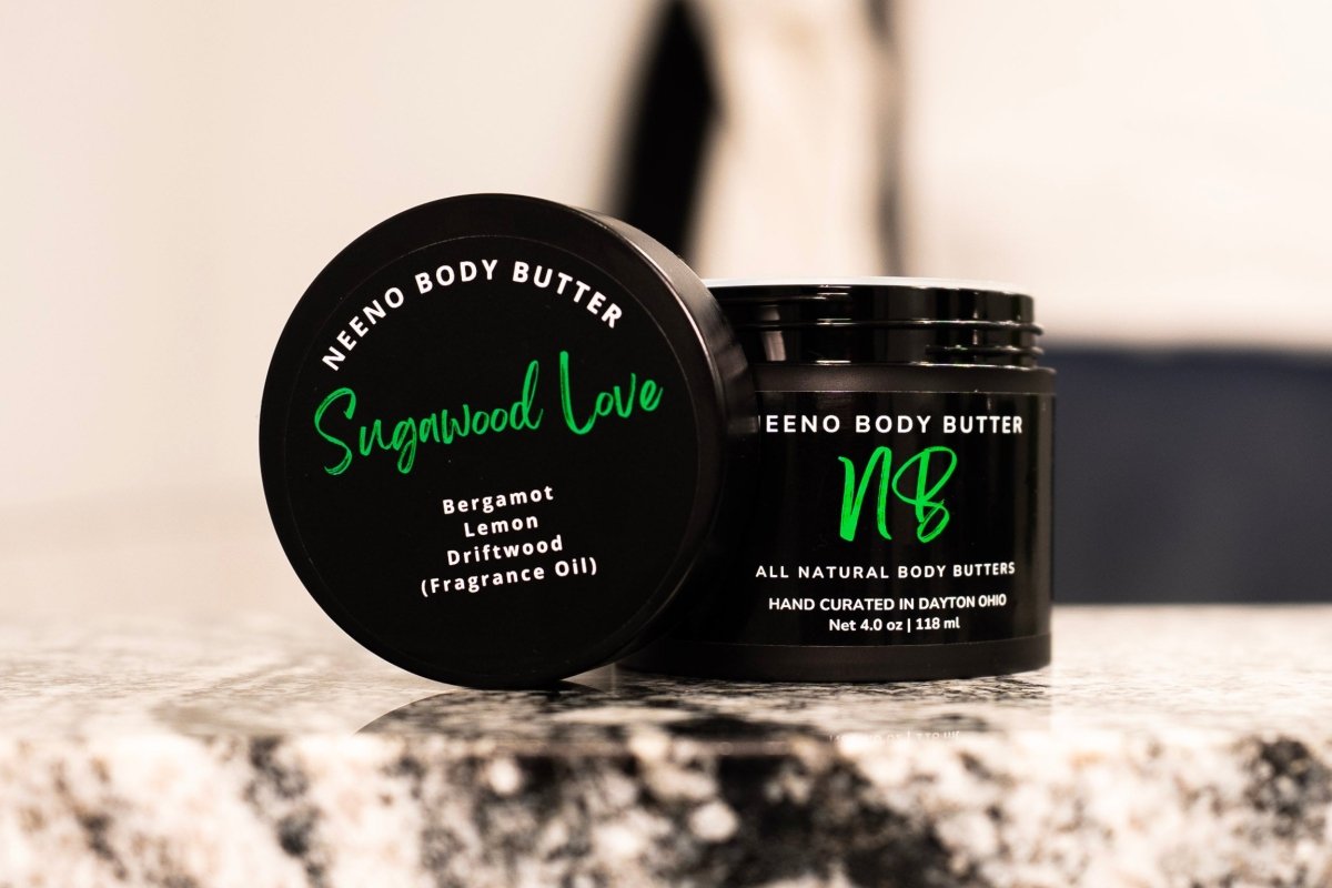 Sugawood body butter by Neeno,  in an elegant black jar with a matching black lid. The product name is displayed in white cursive font on the lid, with the tagline "All Natural Body Butter" 