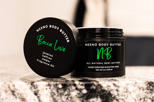 "Bacca LOVE" body butter by Neeno,  in an elegant black jar with a matching black lid. The product name is prominently displayed in a stylish, white, cursive font on the lid, alongside the tagline "All Natural Body Butter" 