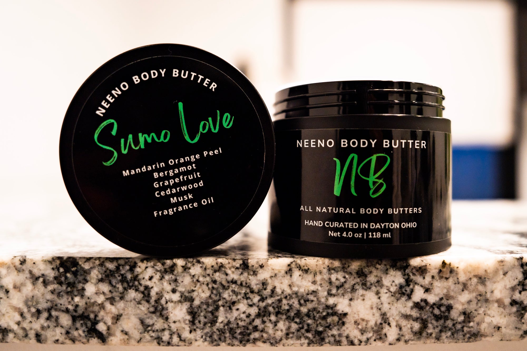 Sumo Love whipped body butter in a Neeno Body branded black jar on a marble countertop